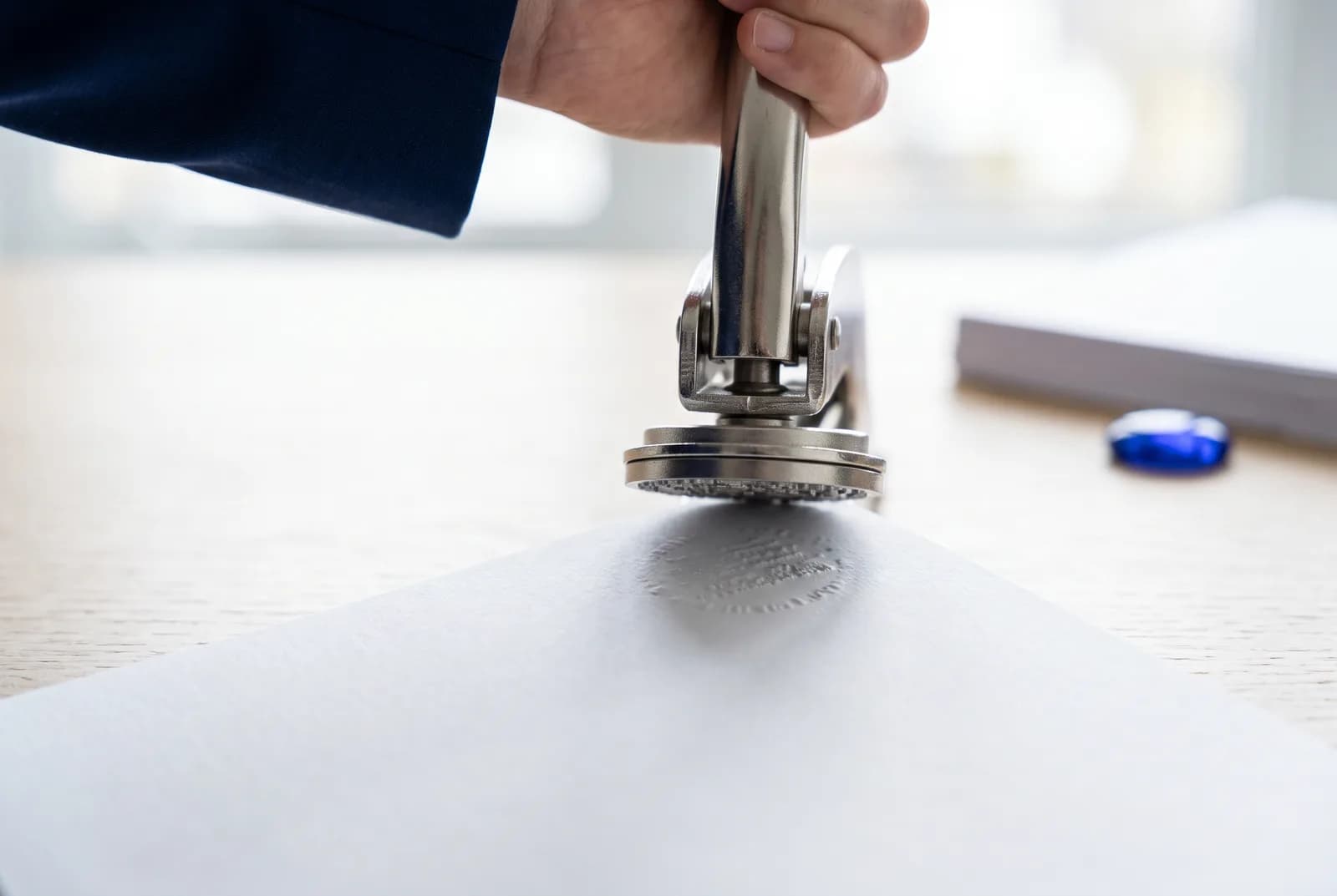 An embossing seal being pressed onto the corner of a document